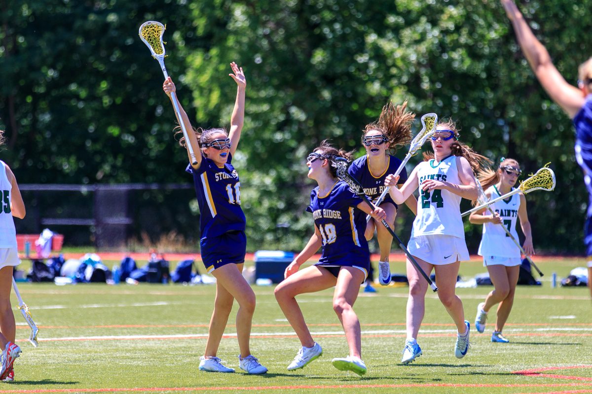 Birdie McKay celebrating with her Stone Ridge lacrosse teammates, Chloe Cassidy and Bray Donahue.